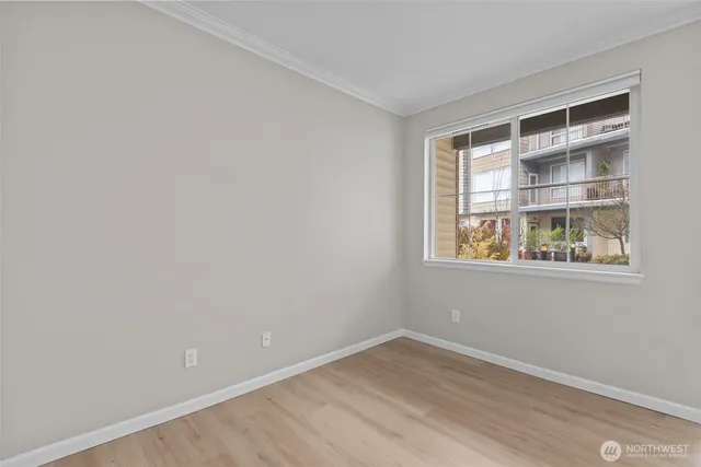 a view of empty room with wooden floor and fireplace