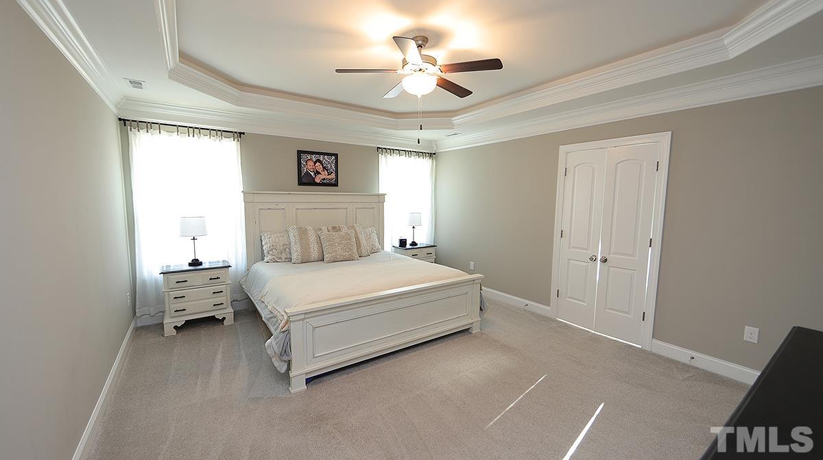 74 Flora Drive Benson, NC 27504 - Photo 17 of 33 a bedroom with a bed and a chandelier