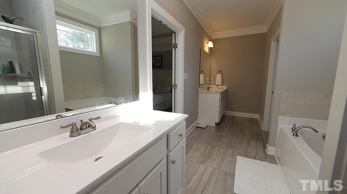 74 Flora Drive Benson, NC 27504 - Photo 19 of 33 a spacious bathroom with a sink a mirror and a shower