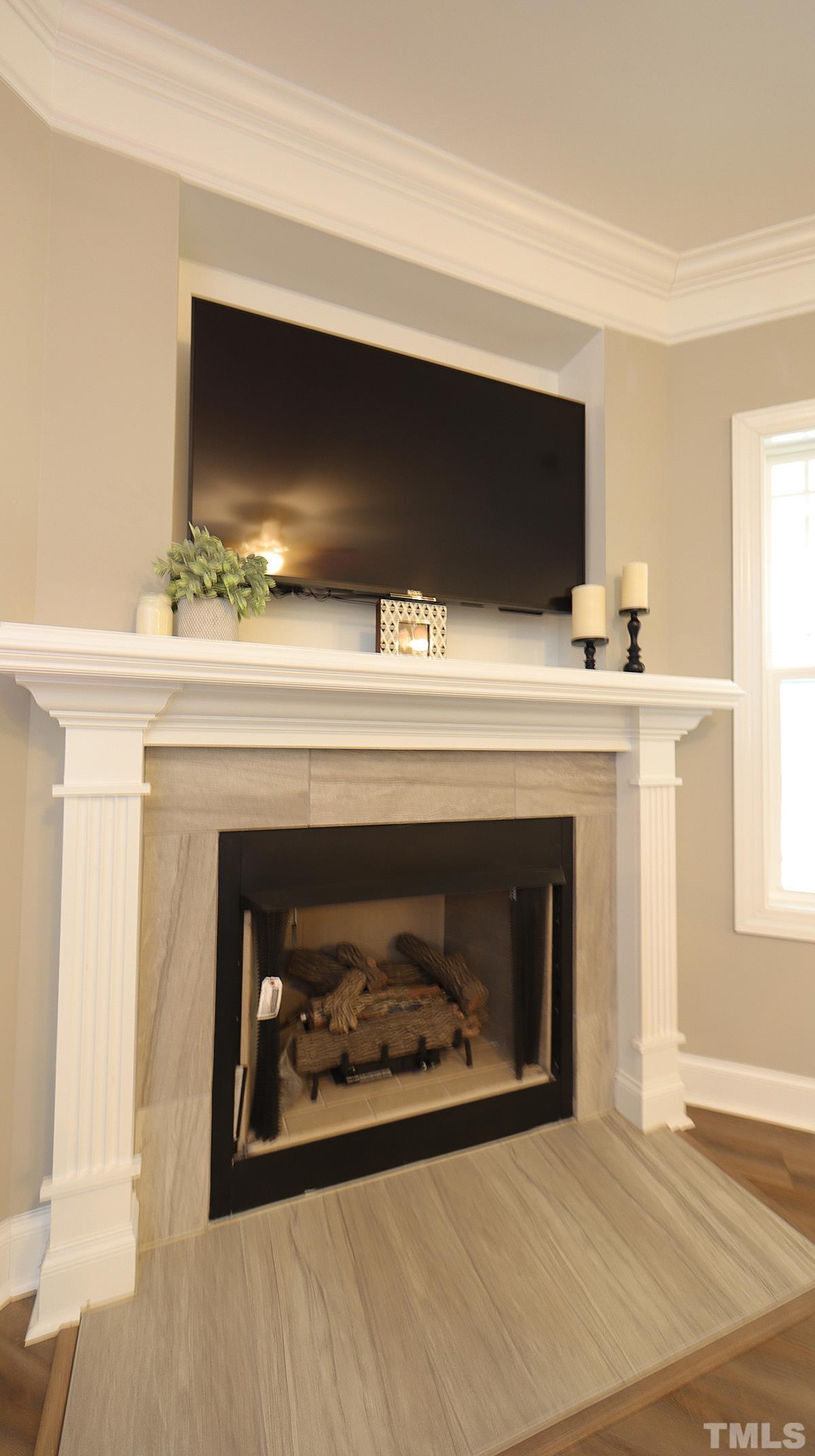 74 Flora Drive Benson, NC 27504 - Photo 8 of 33 a living room with a fireplace and a flat screen tv