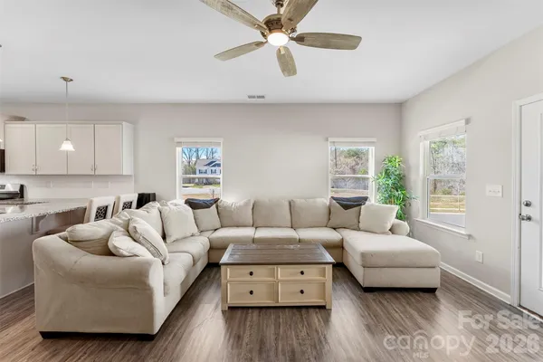 a living room with furniture and a wooden floor