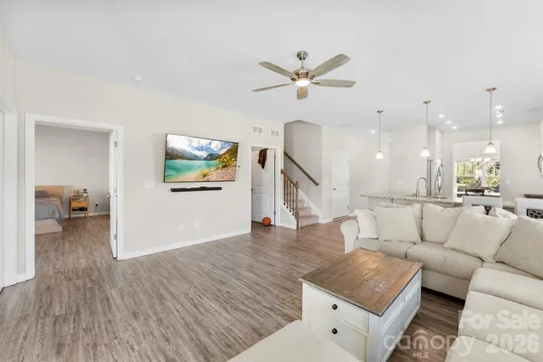 a living room with furniture and a wooden floor