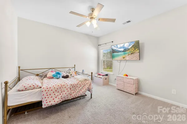 a bedroom with a bed furniture and painting on the wall