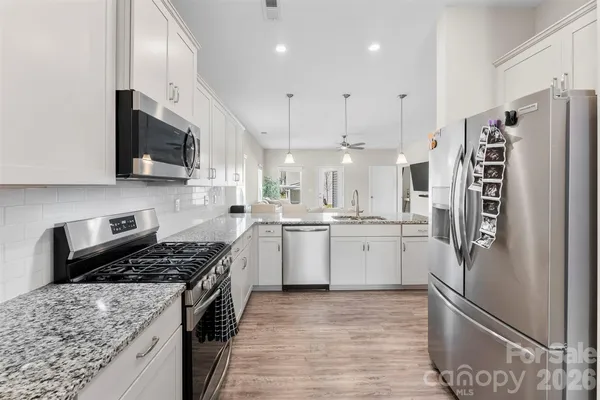 a kitchen with a refrigerator a sink and wooden cabinets