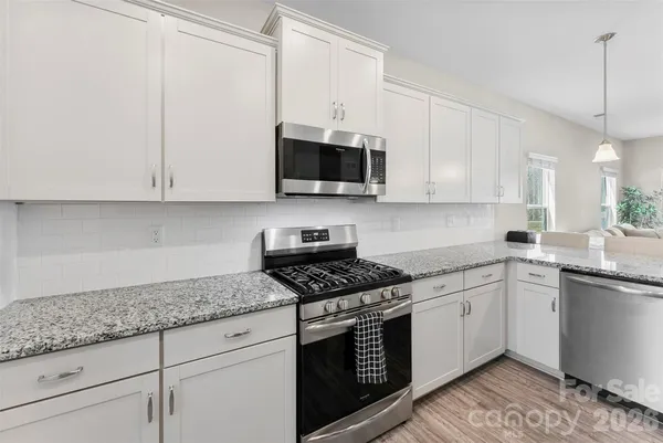 a kitchen with granite countertop a sink a stove and microwave