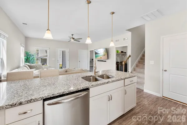 a kitchen with kitchen island a sink and a chandelier