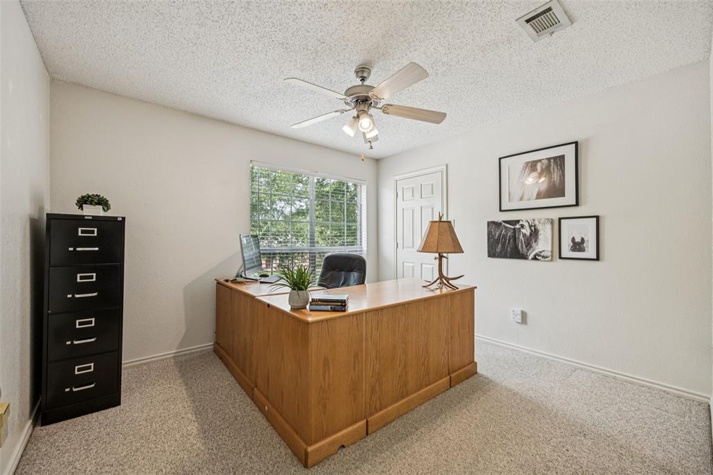 113 Windmill Ridge Drive Rockwall, TX 75032 - Photo 11 of 19 Versatile upstairs bedroom currently used as a home office, featuring neutral tones, a ceiling fan, and bright natural light.