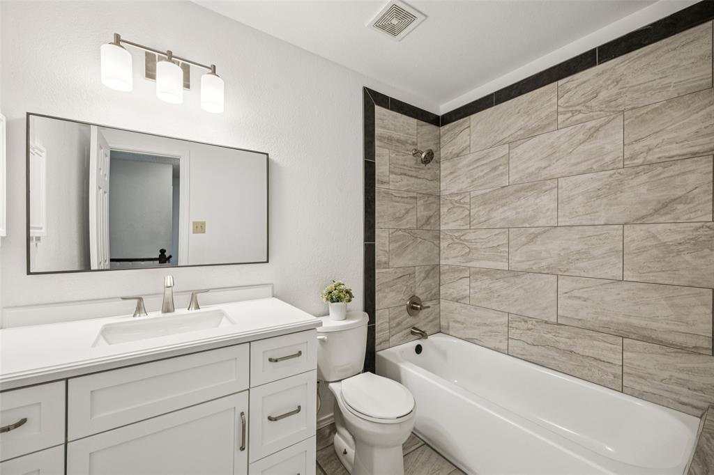 113 Windmill Ridge Drive Rockwall, TX 75032 - Photo 13 of 19 Updated full bath with sleek modern finishes, featuring a large vanity, framed mirror, and contemporary tile surround.