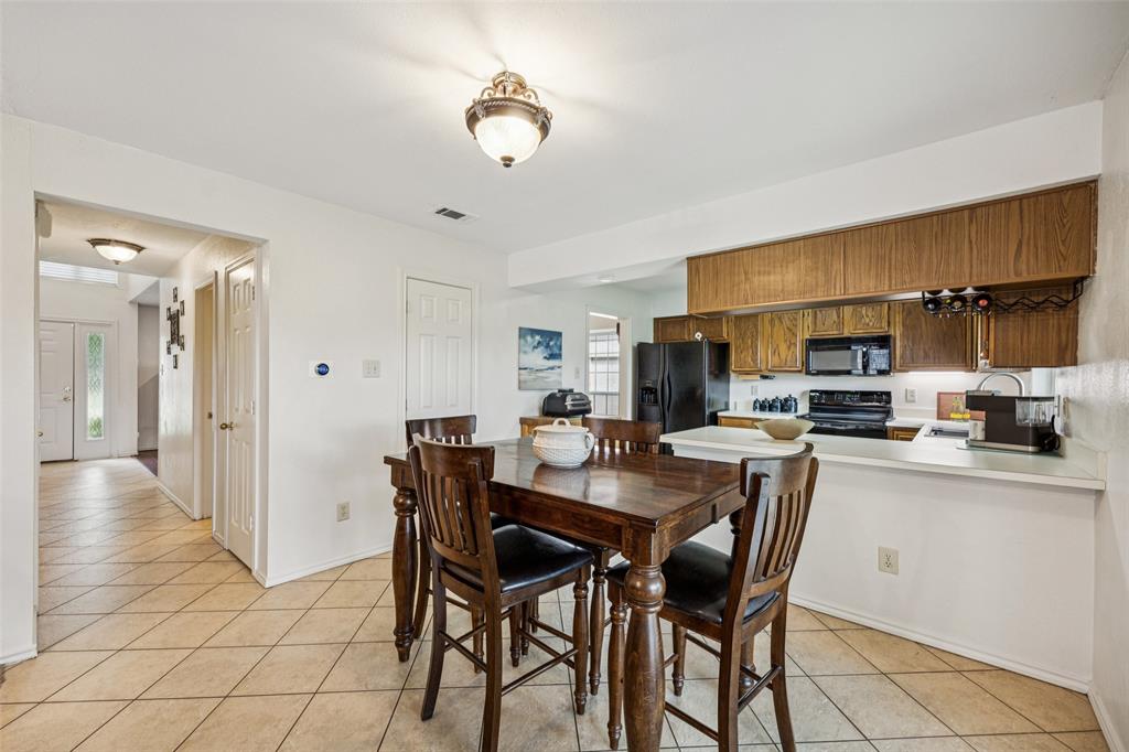 113 Windmill Ridge Drive Rockwall, TX 75032 - Photo 6 of 19 Spacious dining area seamlessly connects to the kitchen and entryway, creating a functional flow for everyday living and entertaining.
