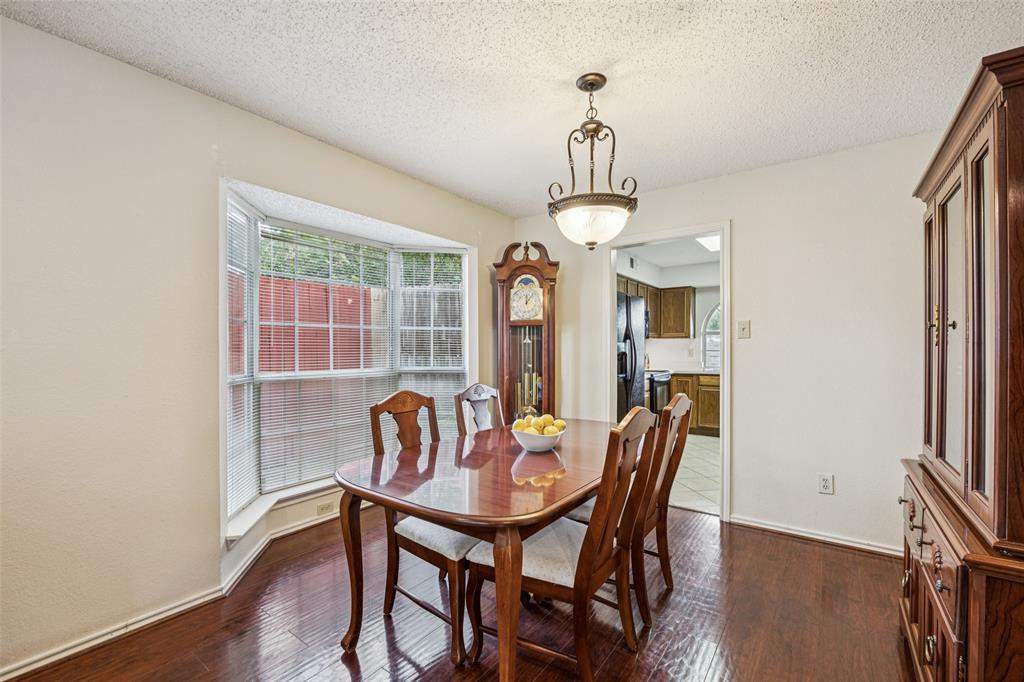 113 Windmill Ridge Drive Rockwall, TX 75032 - Photo 7 of 19 Formal dining room with bay window, wood flooring, and direct access to the kitchen for easy entertaining.