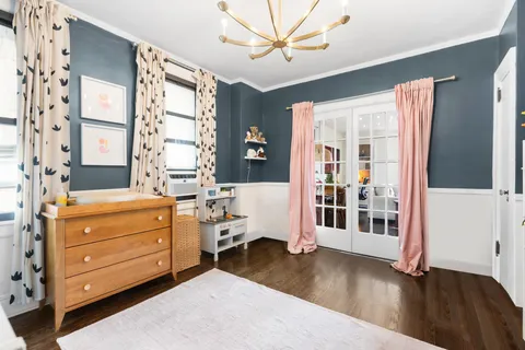 a bedroom with a dresser and a window