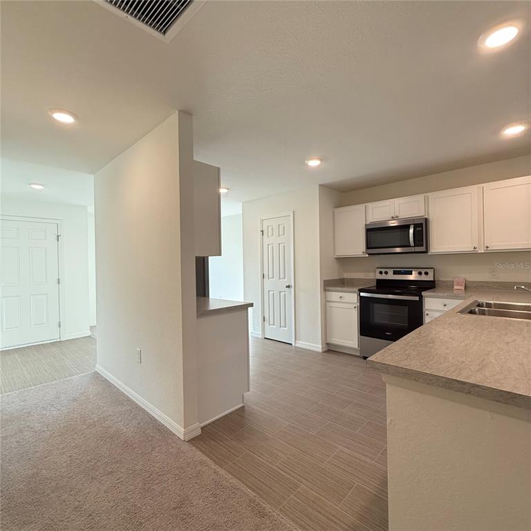 1542 Log Lane North Port, FL 34286 - Photo 11 of 27 a kitchen with granite countertop a refrigerator and a stove top oven