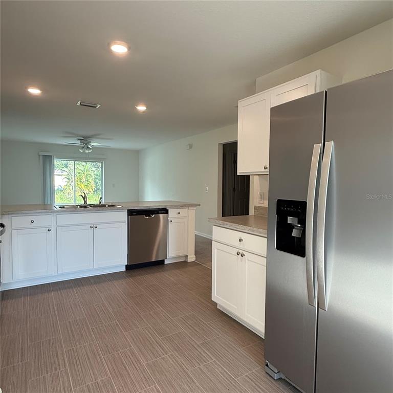 1542 Log Lane North Port, FL 34286 - Photo 13 of 27 a kitchen with stainless steel appliances a refrigerator and a stove top oven