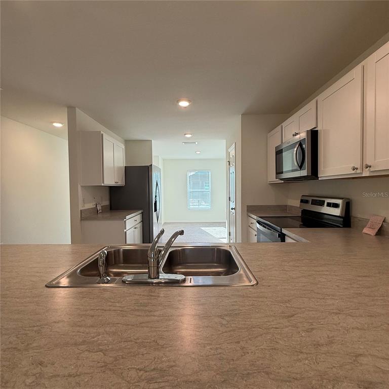 1542 Log Lane North Port, FL 34286 - Photo 14 of 27 a kitchen with kitchen island a sink stainless steel appliances and cabinets