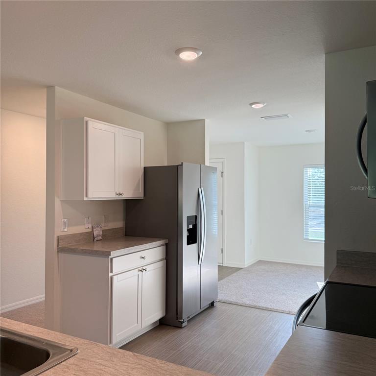 1542 Log Lane North Port, FL 34286 - Photo 15 of 27 a kitchen with stainless steel appliances a refrigerator sink and cabinets