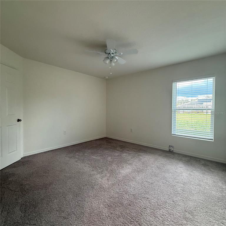 1542 Log Lane North Port, FL 34286 - Photo 18 of 27 an empty room with a window and a ceiling fan