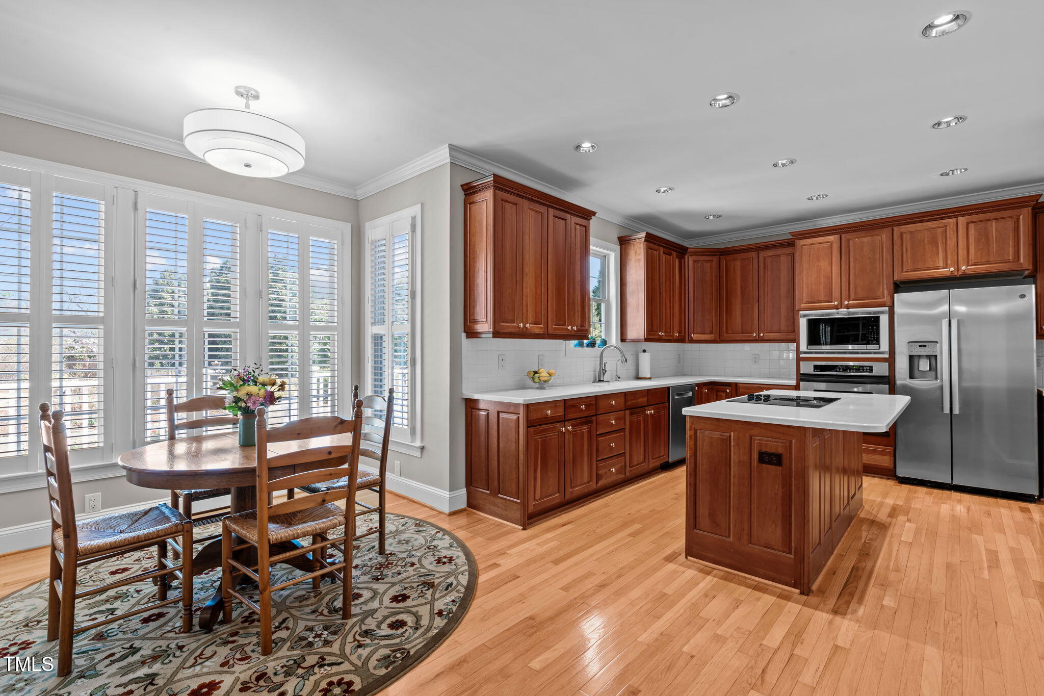 3708 Wesley Ridge Drive Apex, NC 27539 - Photo 15 of 48 a kitchen with stainless steel appliances wooden floors and wooden cabinets
