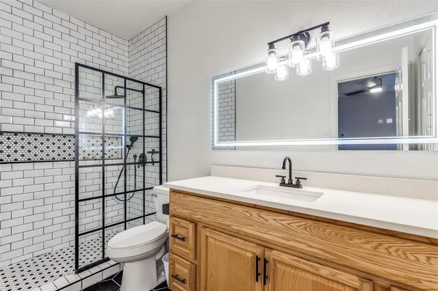 a bathroom with a sink toilet vanity and shower