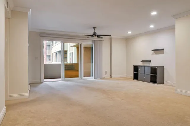 a view of an empty room with a kitchen and a window