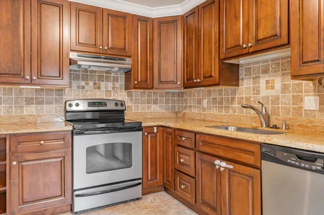 a kitchen with stainless steel appliances granite countertop a sink stove and cabinets