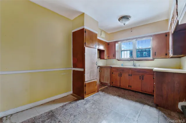 a kitchen with granite countertop a refrigerator and a sink