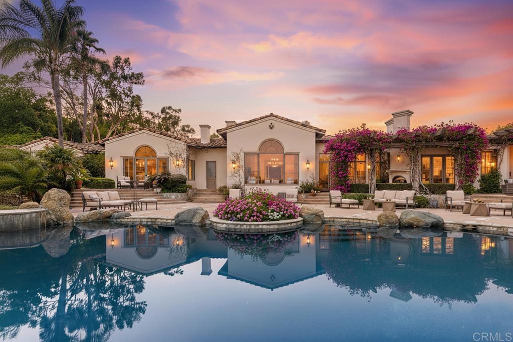 a view of a white house with swimming pool and chairs