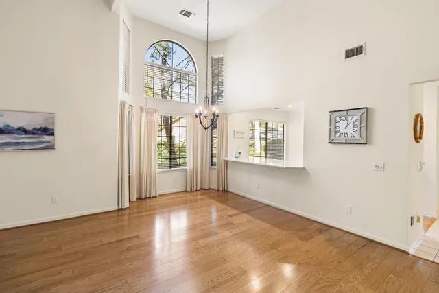 a large white kitchen with a refrigerator a sink dishwasher a oven with white cabinets and wooden floor