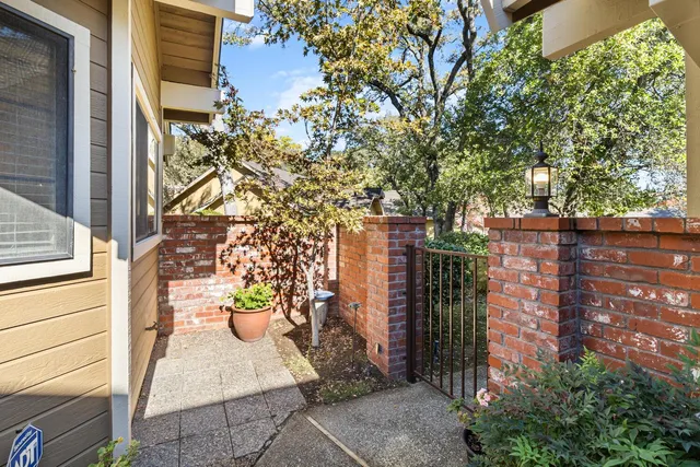 a view of a brick house with potted plants