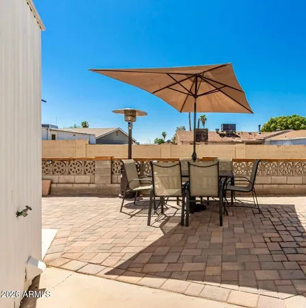a view of a patio with a table and chairs under an umbrella