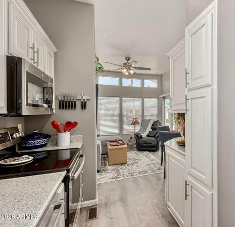 a kitchen with stainless steel appliances kitchen island granite countertop a sink dishwasher stove and white cabinets