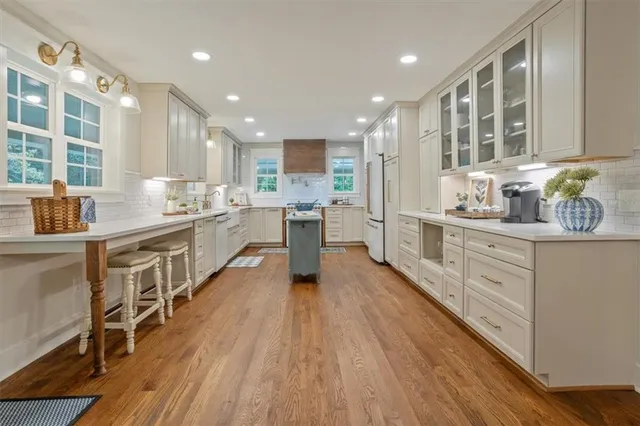 a kitchen with counter top space a sink wooden floor and stainless steel appliances