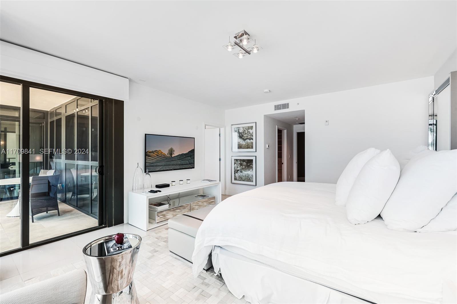 2205 South Surf Road, Unit 3A Hollywood, FL 33019 - Photo 20 of 58 a bedroom with a large bed and a flat tv screen on dresser