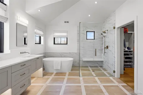 a bathroom with a bathtub shower sink vanity and toilet