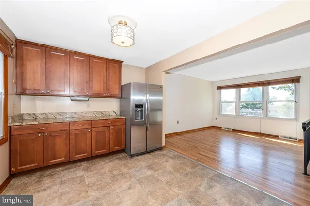 a view of an empty room with wooden floor and closet