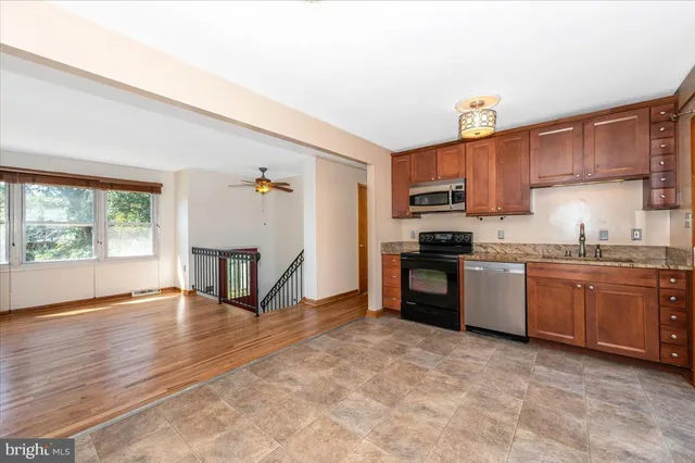 a bathroom with a granite countertop sink a toilet and a mirror