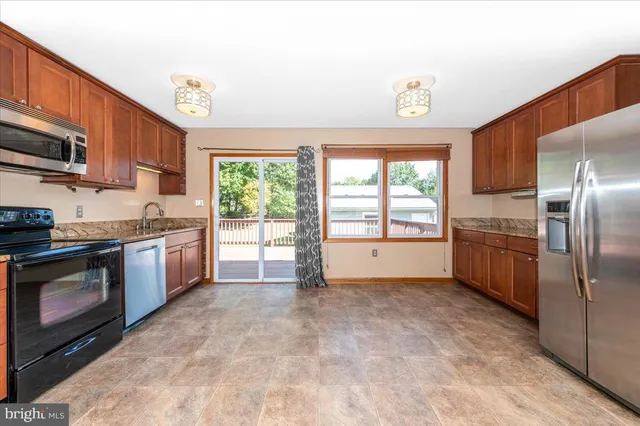 a kitchen with stainless steel appliances granite countertop a stove a sink and a refrigerator