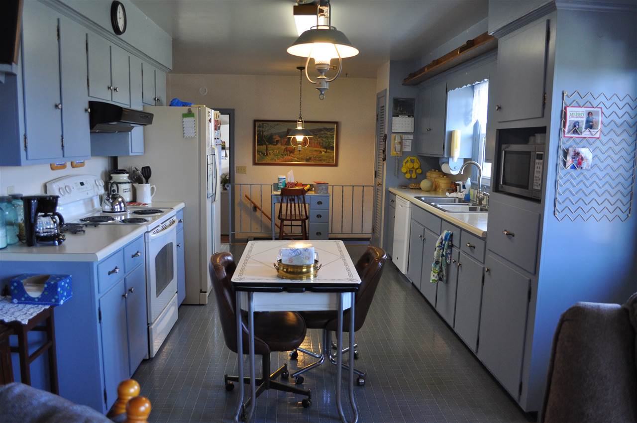 363 Varner Road Churchville, VA 24421 - Photo 11 of 17 a kitchen with stainless steel appliances kitchen island granite countertop a table chairs in it and wooden floors