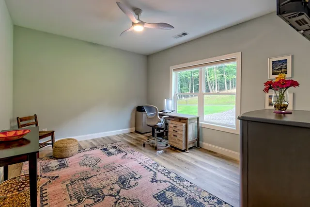 a living room with furniture a fireplace a flat screen tv and windows