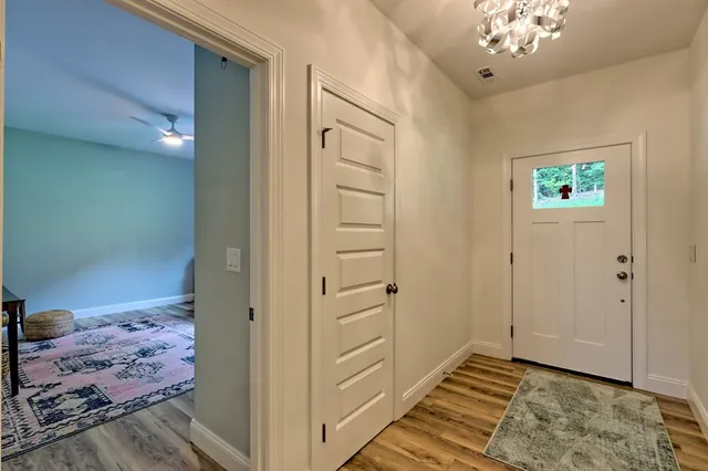 a view of a hallway view with wooden floor and dining room