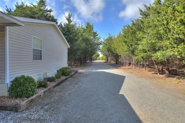 a view of backyard of house with green space
