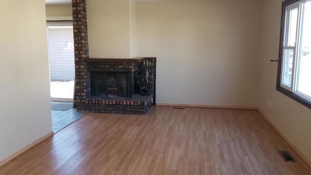 133 Heathgate Road Montgomery, IL 60538 - Photo 13 of 34 a view of a room with wooden floor a fireplace and a window
