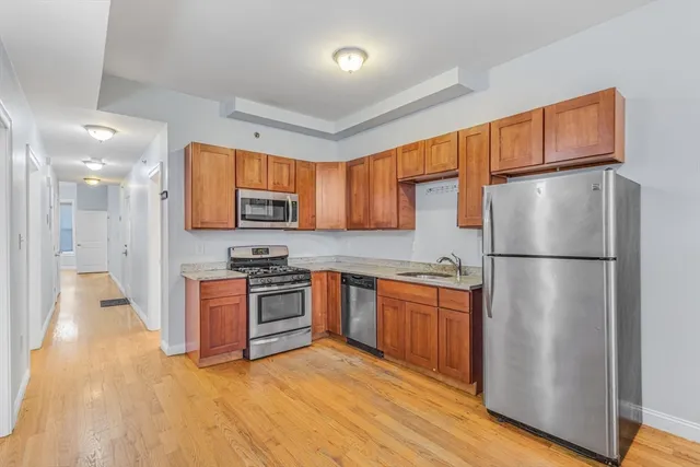 a kitchen with stainless steel appliances granite countertop a refrigerator stove top oven and sink