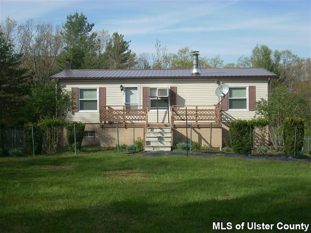 a view of a house with a yard and sitting area