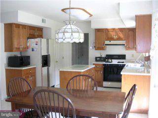 3014 Regency Drive Sinking Spring, PA 19608 - Photo 5 of 6 a kitchen with stainless steel appliances granite countertop a stove a refrigerator a kitchen island a dining table and chairs with wooden floor