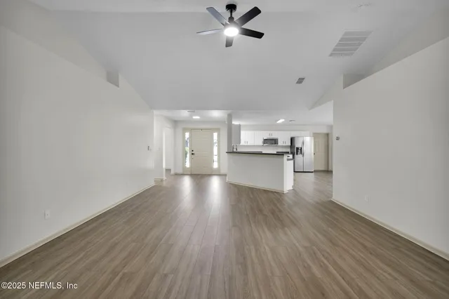 a view of a kitchen with a sink and wooden floor