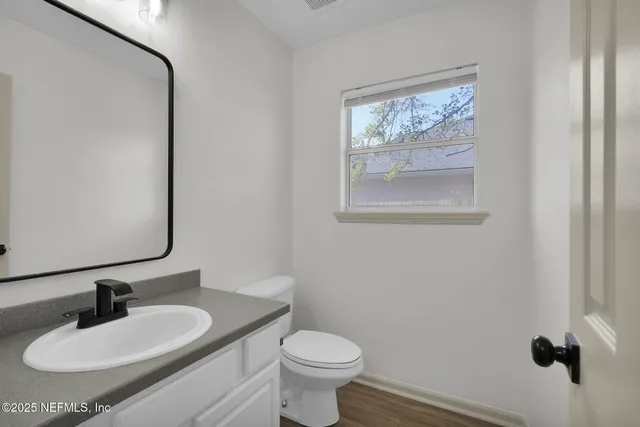 a bathroom with a toilet sink and mirror