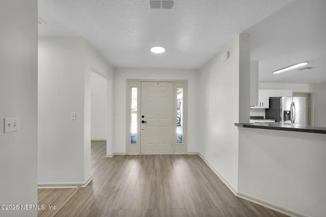 a view of a kitchen with wooden floor and a sink