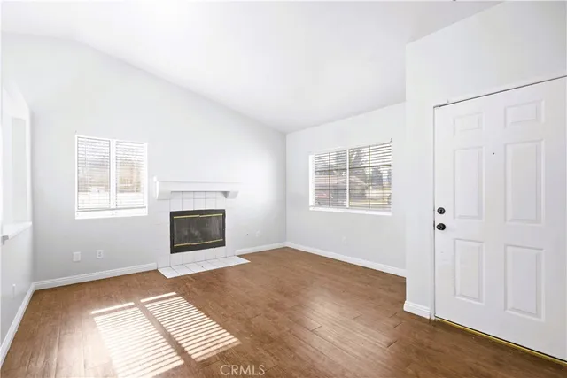 an empty room with windows fireplace and a sink
