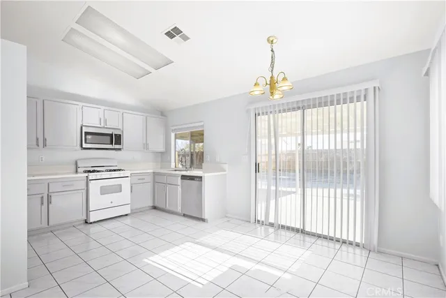 a kitchen with white cabinets and appliances