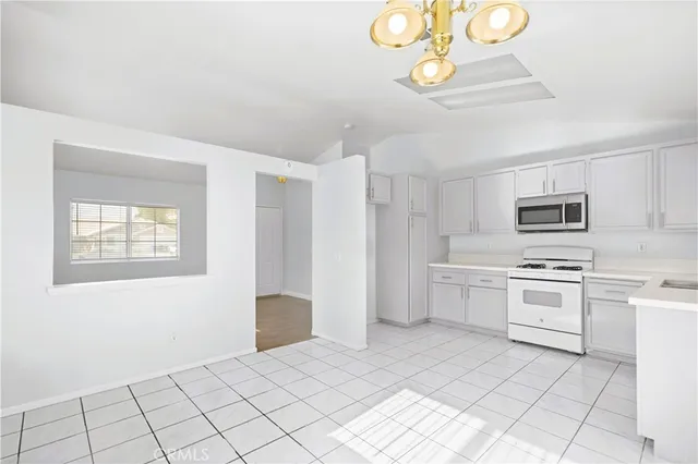 a kitchen with white cabinets and appliances